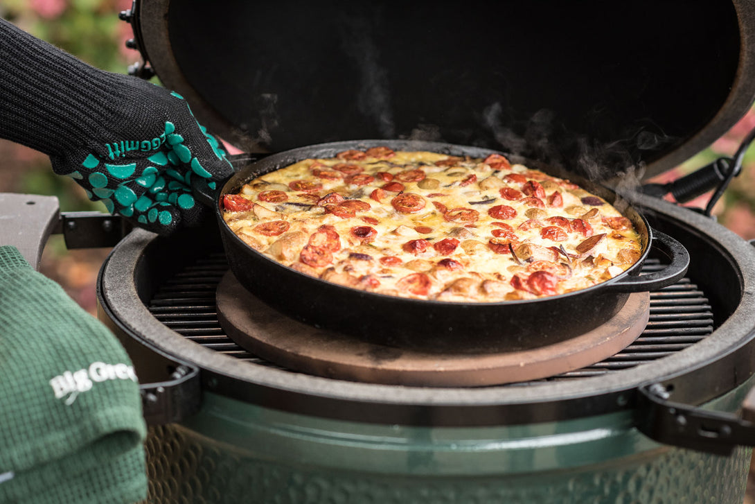 Frissen sült frittata öntöttvas serpenyőben Big Green Egg grillben, hőálló kesztyűvel kiemelve, convEGGtor és pizzakő fölött sütve.