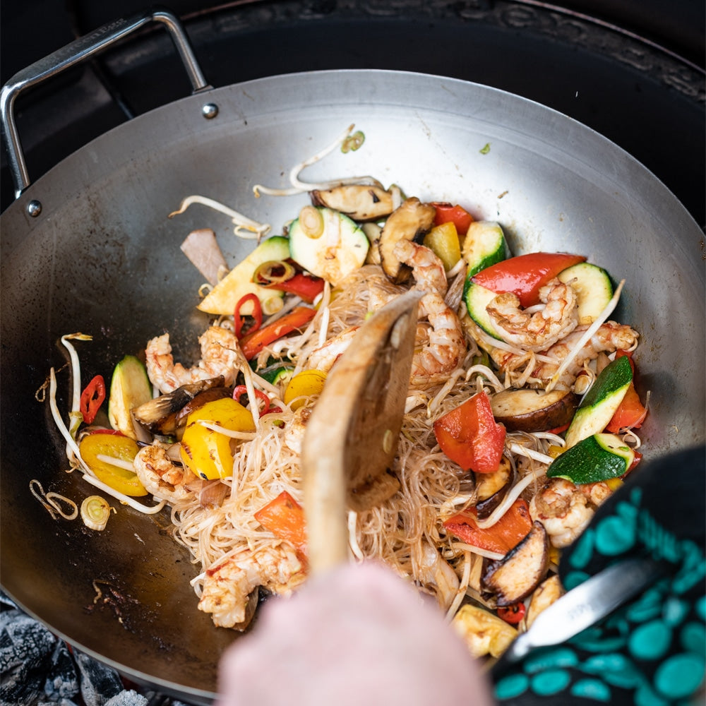Big Green Egg wokban készült ázsiai jellegű étel: üvegtészta, garnéla, paprika, cukkinivel és gombával, grillezés közben