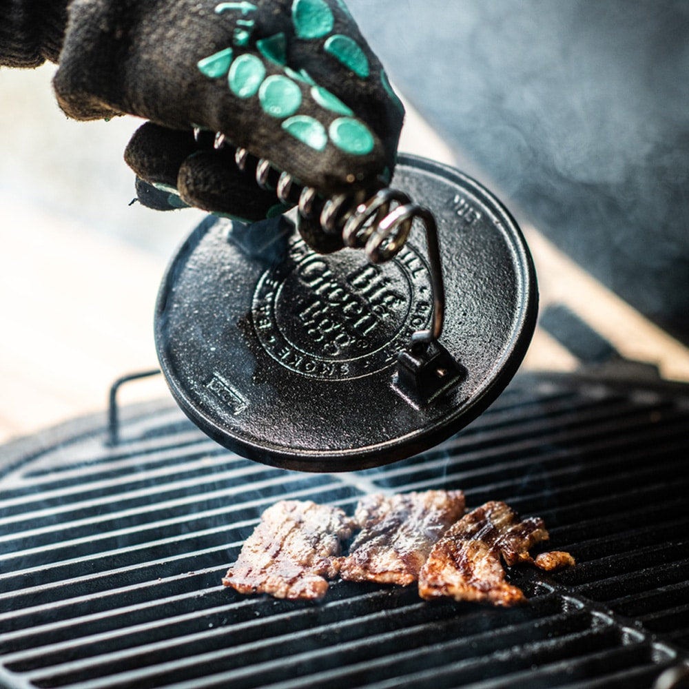 Big Green Egg öntöttvas grillnyomó használat közben – húsprés grillezett szeleteken