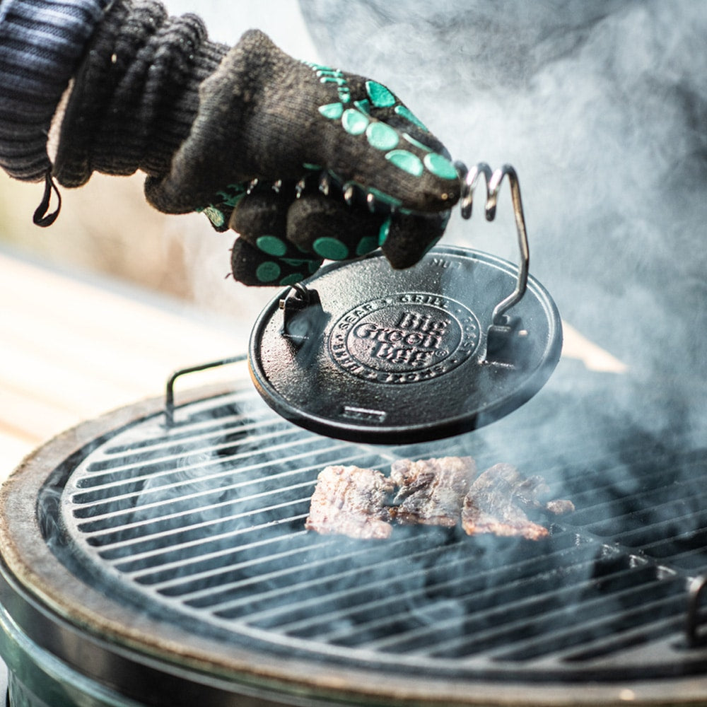 Big Green Egg öntöttvas grillnyomó használat közben – húsprés grillezett szeleteken