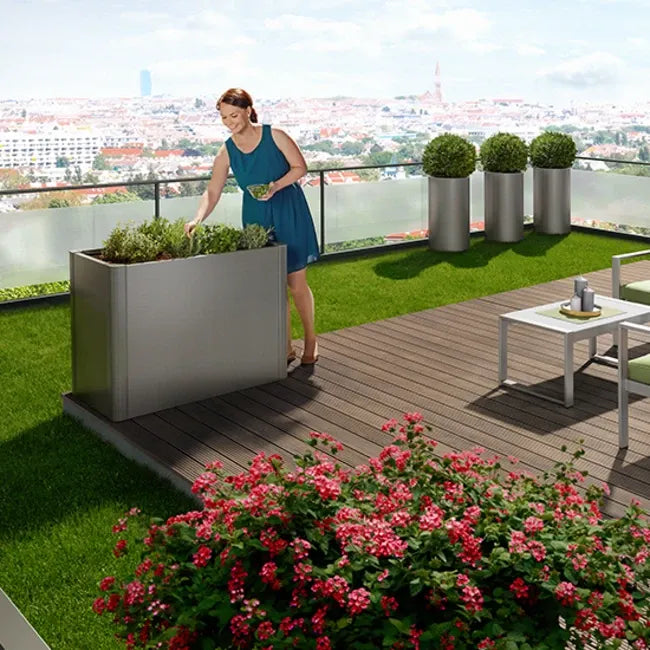 Biohort Belvedere magaságyás ezüstszürke színben – modern fém növénytartó erkélyre vagy teraszra, városi panorámával.
