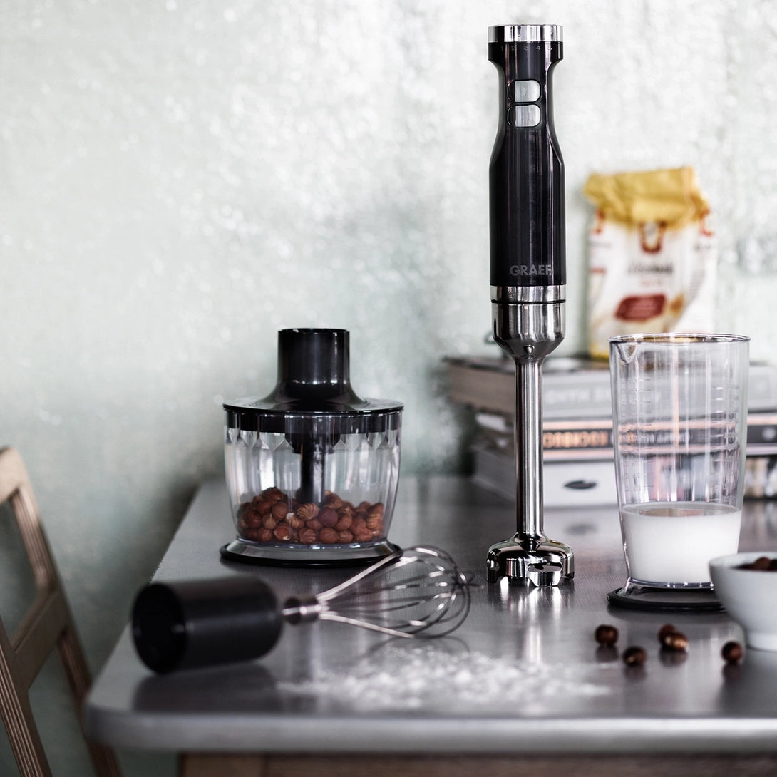 GRAEF HB502 botmixer konyhai jelenetben, mérőpohárral, habverővel és aprítóval.