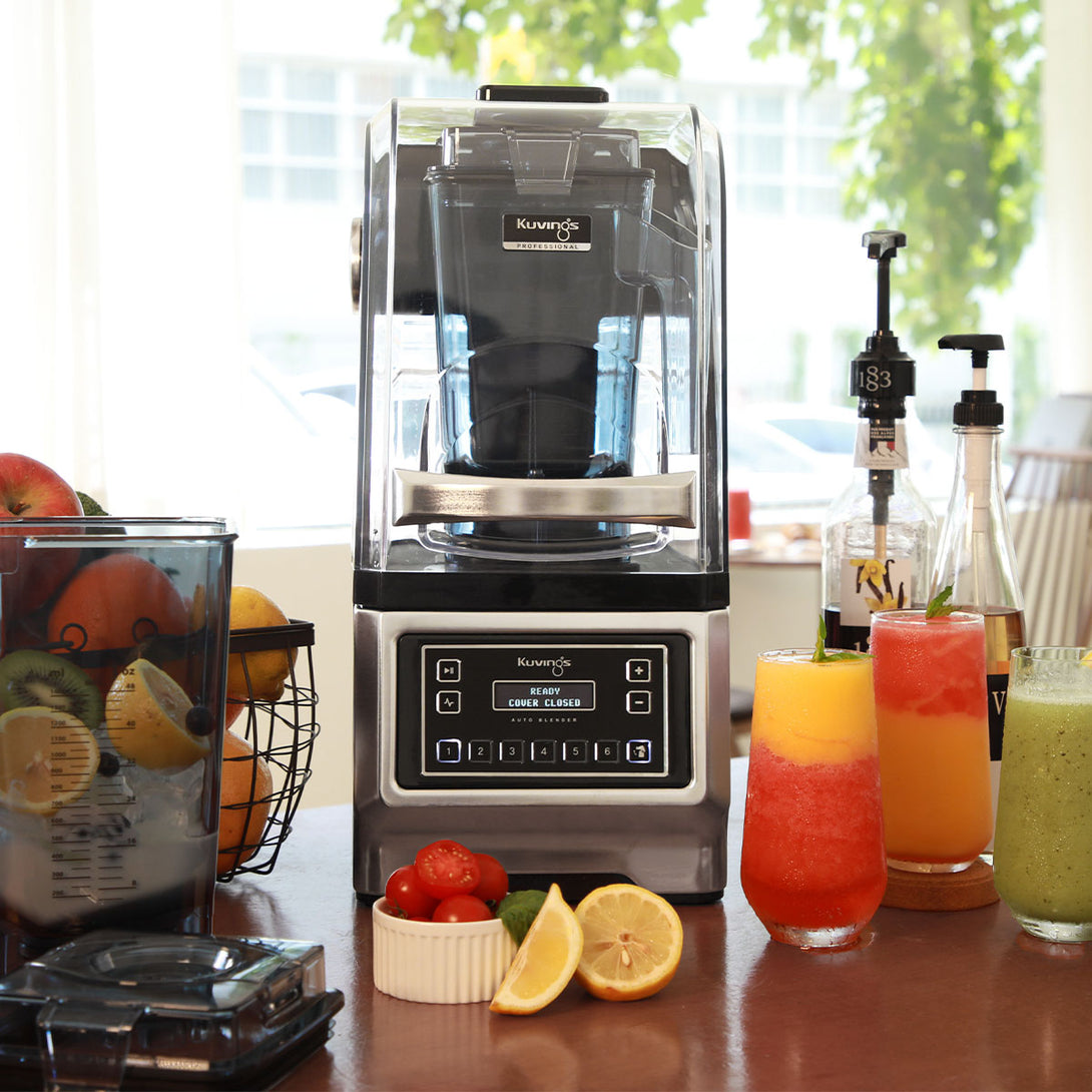 Kuvings CB980 professzionális auto turmixgép zajvédő burkolattal, friss smoothie-italokkal egy kávézó pultján