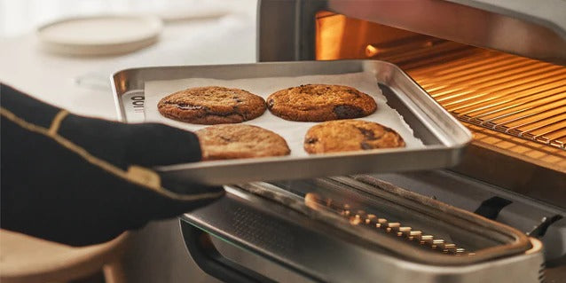 Csokis kekszek sütése tepsin az Ooni Volt 2-ben; egyenletes hőeloszlás többfunkciós használathoz.