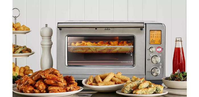 Sage The Smart Oven Air Fryer Házi Elektromos Minisütő SOV860BSS elölnézet, különböző - a sütőben készült - ételekkel.