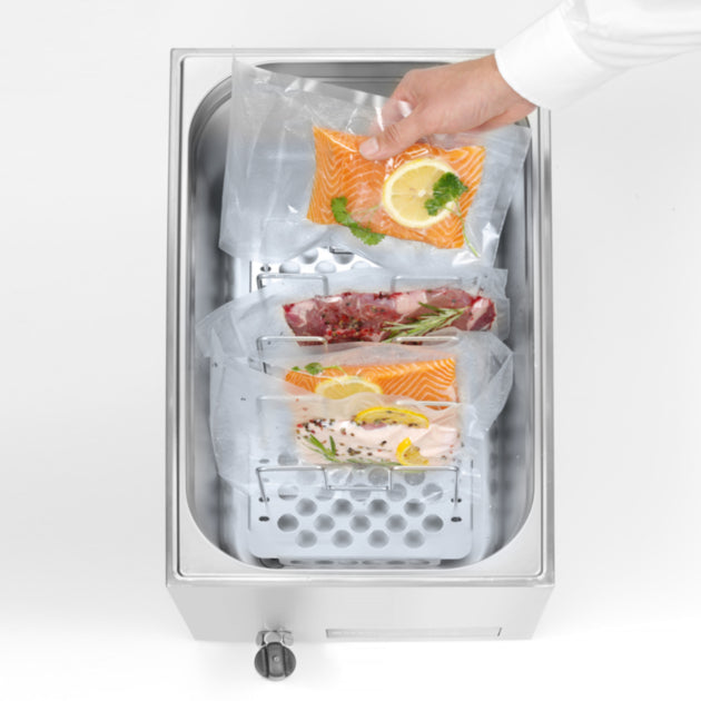 Sous vide vákuumcsomagolt húsok és halak elkülönítve a SousVideTools 28 literes kád elválasztóival