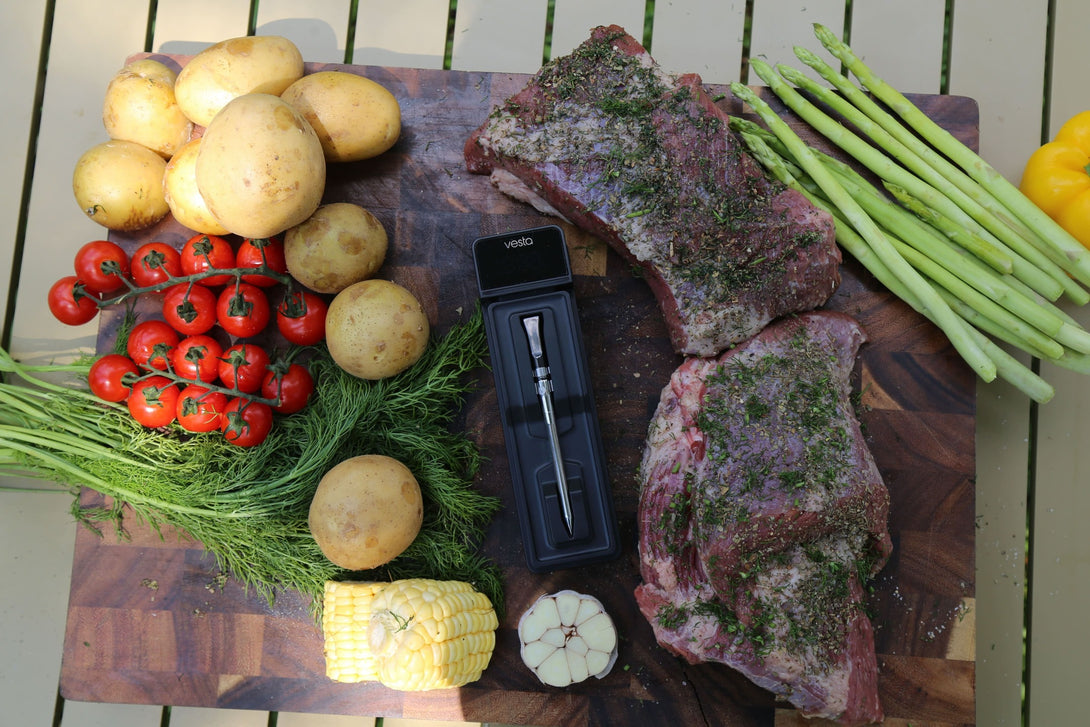 Felülnézet: zöldségek, fűszerezett húsok és a Vestemp BP20 dokkoló egy vágódeszkán.