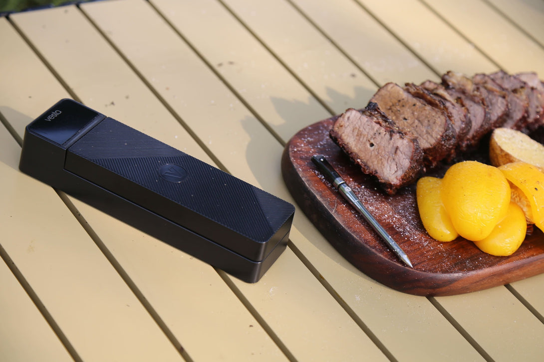 Vestemp BP20 dokkoló kempingasztalon, mellette szeletelt sült hús és a hőmérő szonda a fatálon.